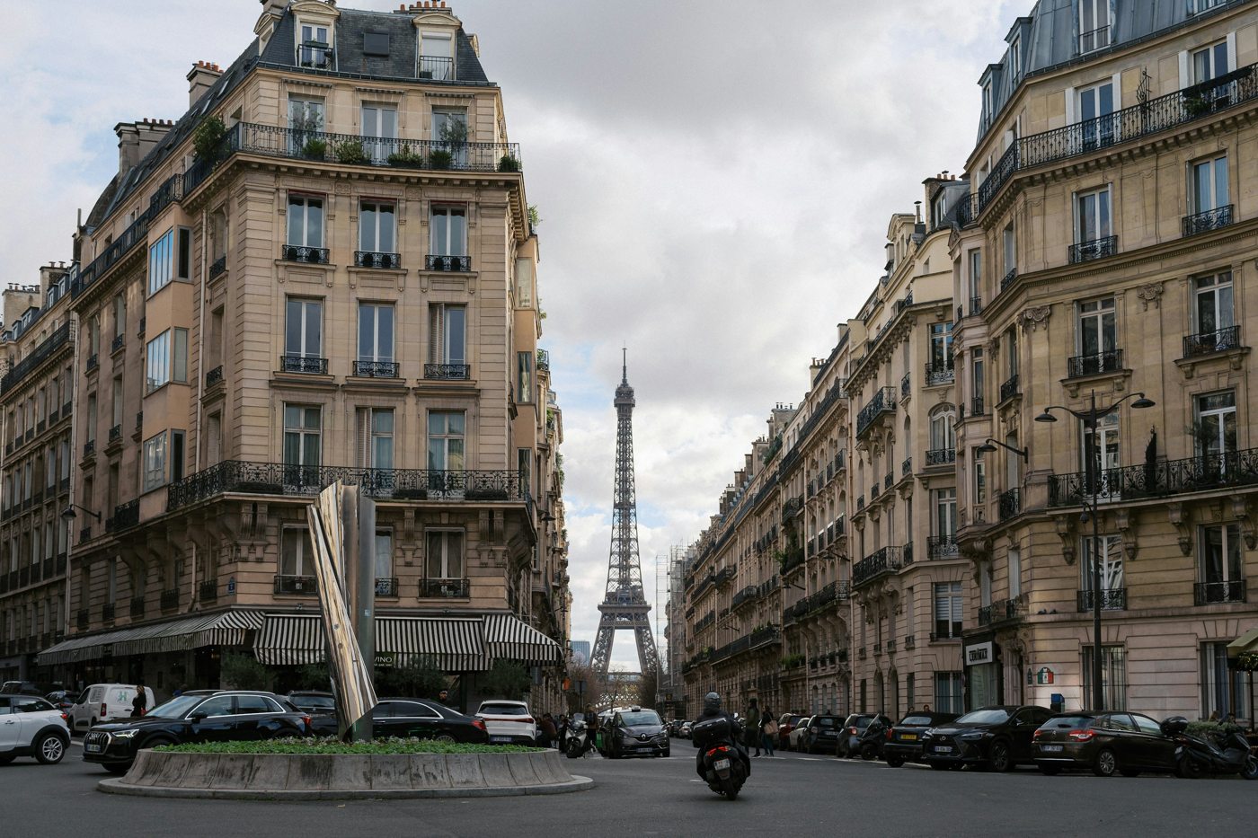 Parisian stone façades framing a distant view of the Eiffel Tower